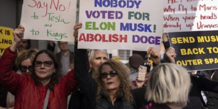 Elon Musk: अमेरिका में एलन मस्क के खिलाफ बड़ा विरोध प्रदर्शन, टेस्ला के बाहर लोगों ने जमकर की नारेबाजी 